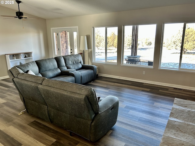 living room with dark wood finished floors, visible vents, a ceiling fan, vaulted ceiling, and baseboards