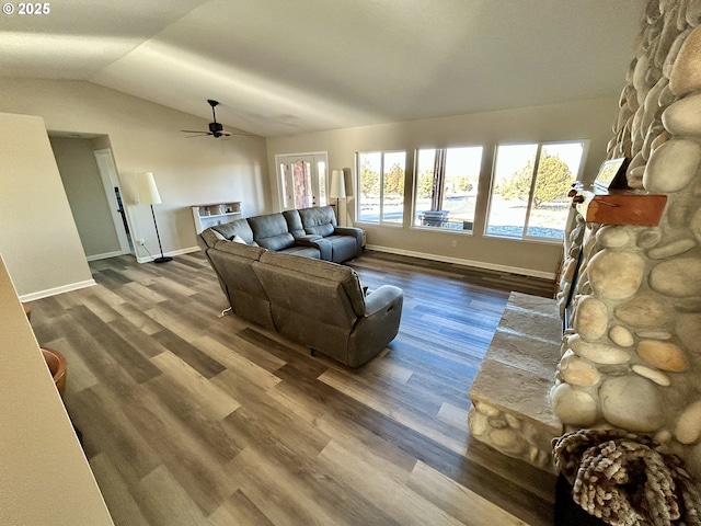 living room featuring lofted ceiling, wood finished floors, and baseboards