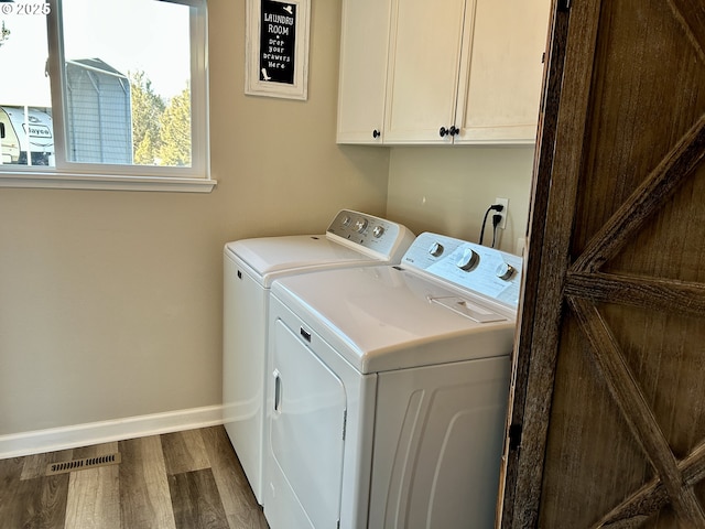 laundry area with washing machine and clothes dryer, visible vents, baseboards, cabinet space, and dark wood finished floors