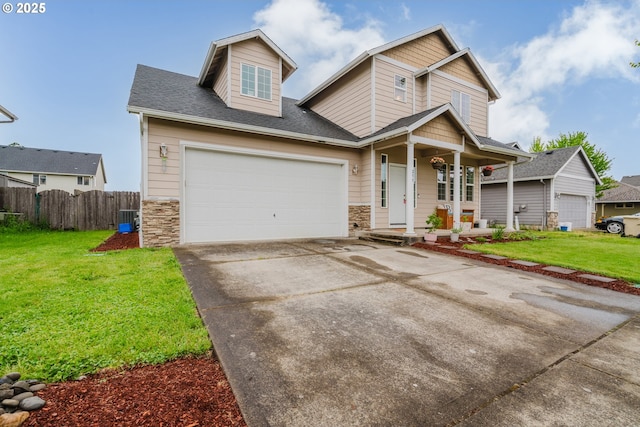 311 W Jadon Dr, Lebanon, OR 97355 - view of front of property with a porch, stone siding, central air condition unit, driveway, and an attached garage