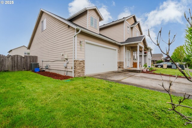 311 W Jadon Dr, Lebanon, OR 97355 - view of front of home with concrete driveway, central AC, an attached garage, and stone siding