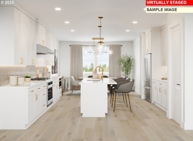 kitchen featuring under cabinet range hood, white cabinets, and light wood-style flooring