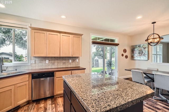 kitchen with a sink, dishwasher, wood finished floors, and light brown cabinets