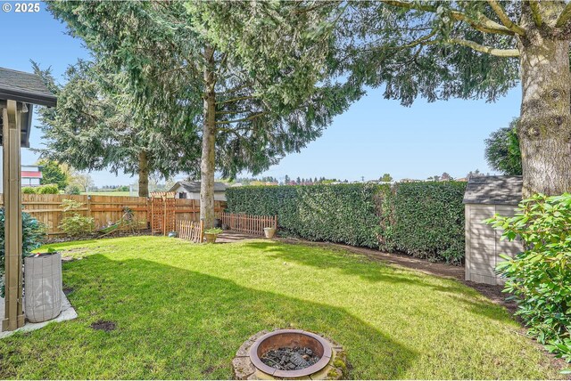 view of yard with a fire pit and a fenced backyard