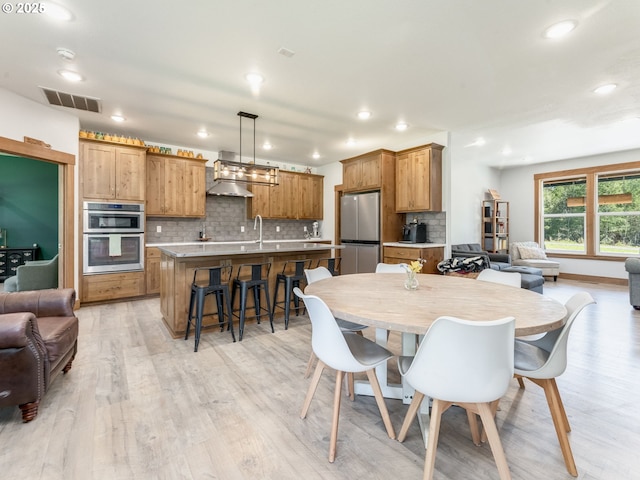 dining area with recessed lighting, light wood-style flooring, and visible vents