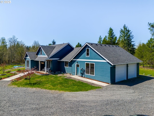 view of front facade featuring a garage, a shingled roof, and a front yard