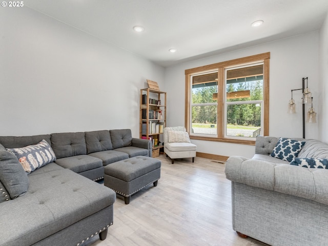 living area with light wood-style flooring, baseboards, and recessed lighting