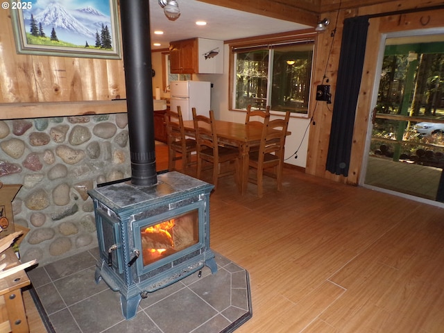 interior space featuring a wood stove, wood finished floors, and freestanding refrigerator