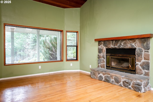 unfurnished living room featuring hardwood / wood-style flooring and a stone fireplace