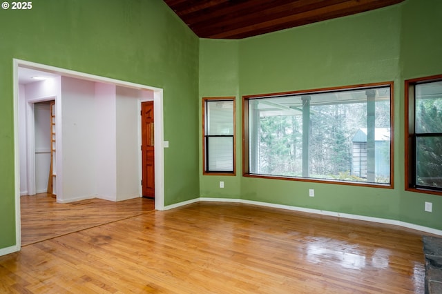 interior space featuring wood ceiling, plenty of natural light, light hardwood / wood-style floors, and a high ceiling