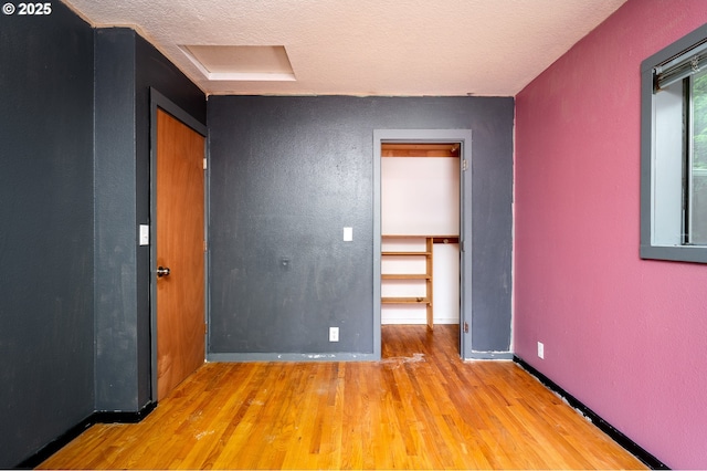 spare room featuring light hardwood / wood-style flooring and a textured ceiling