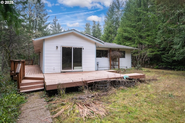 back of house featuring a wooden deck and a yard