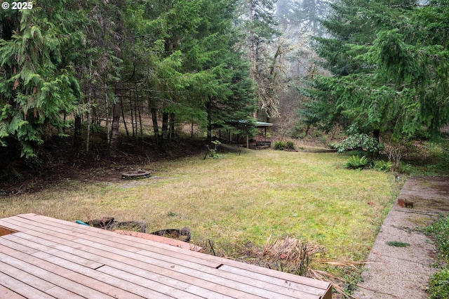 view of yard with a wooden deck and a fire pit