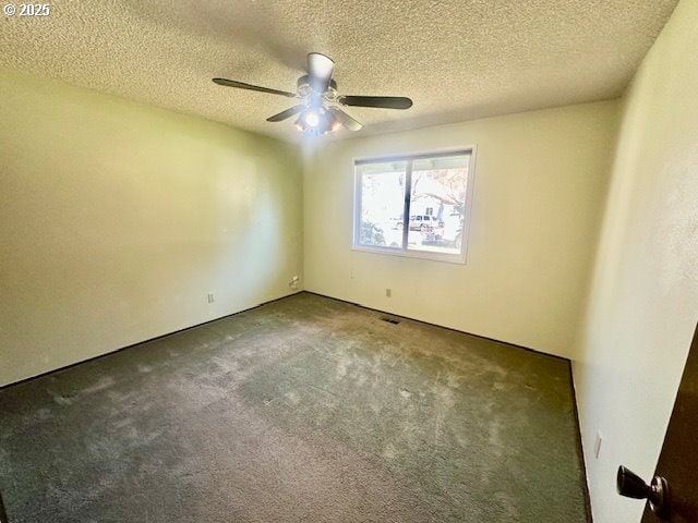 carpeted empty room featuring ceiling fan and a textured ceiling