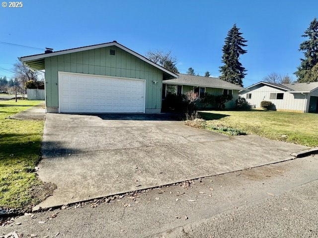 ranch-style home with a garage, concrete driveway, and a front lawn