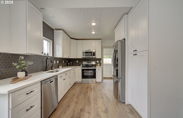 126 NE Garfield St, Camas, WA 98607 - kitchen featuring appliances with stainless steel finishes, white cabinetry, light wood finished floors, tasteful backsplash, and recessed lighting