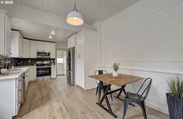 126 NE Garfield St, Camas, WA 98607 - kitchen with appliances with stainless steel finishes, wood ceiling, light countertops, crown molding, and white cabinets