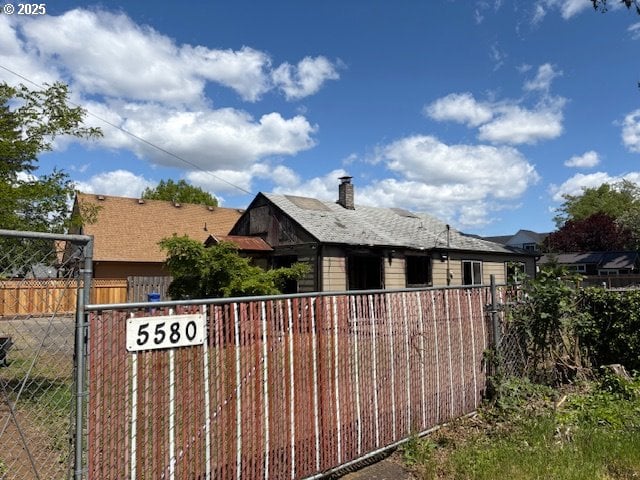 view of side of property with fence and a chimney