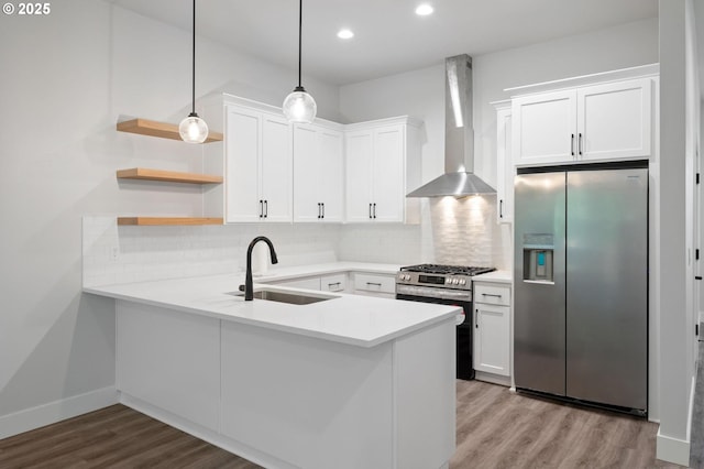 9258 SW Waverly Dr, Tigard, OR 97224 - kitchen featuring appliances with stainless steel finishes, wall chimney range hood, a sink, a peninsula, and wood finished floors