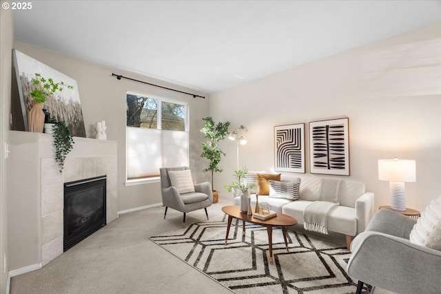 carpeted living area featuring baseboards and a tile fireplace