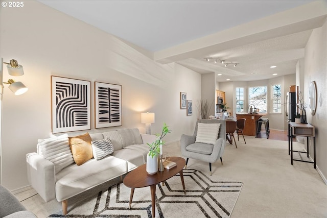 living area with recessed lighting, light colored carpet, and baseboards