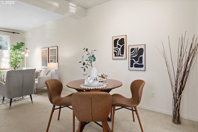 dining room with baseboards and light colored carpet