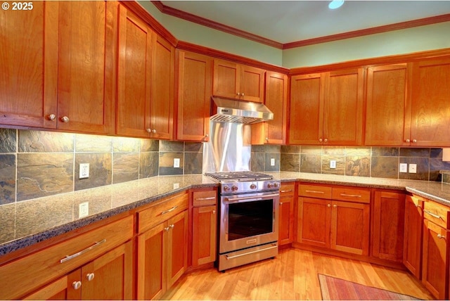 kitchen featuring stone counters, stainless steel gas range, light wood-type flooring, ornamental molding, and backsplash