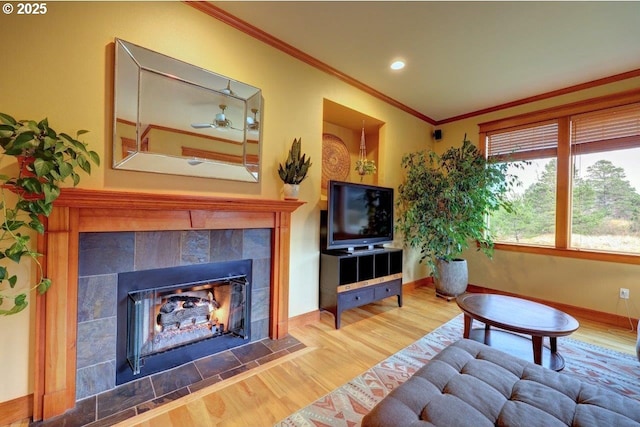 living room featuring ornamental molding, hardwood / wood-style floors, and a tile fireplace