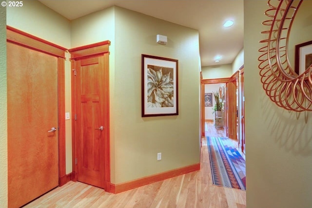 corridor with light hardwood / wood-style floors