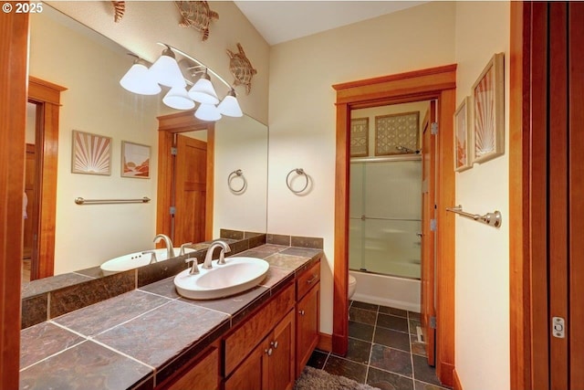 full bathroom featuring toilet, shower / bath combination with glass door, and vanity