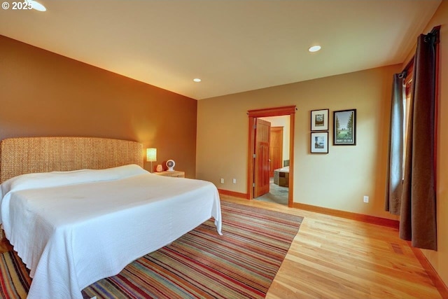 bedroom with light hardwood / wood-style floors and connected bathroom