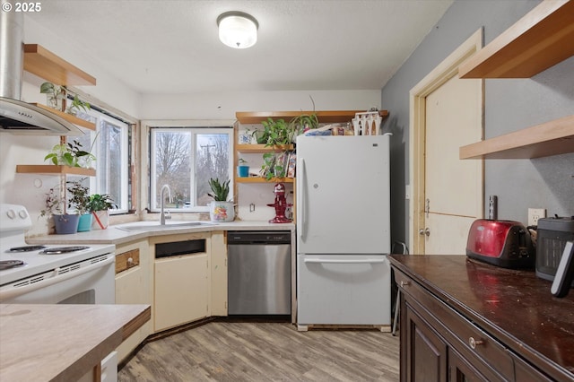 kitchen featuring white appliances, light wood-style floors, open shelves, and a sink