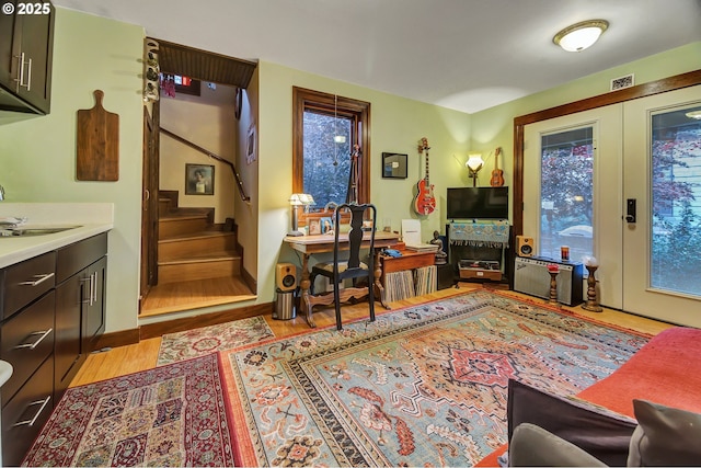 interior space with french doors, light hardwood / wood-style floors, and sink