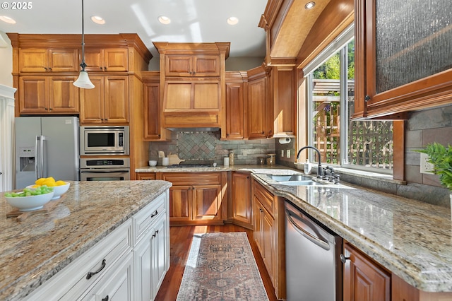 7102 SW 78th Ave, Portland, OR 97223 - kitchen featuring appliances with stainless steel finishes, a sink, brown cabinets, dark wood-style flooring, and decorative backsplash