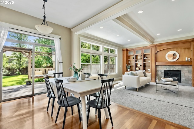 7102 SW 78th Ave, Portland, OR 97223 - dining space with ornamental molding, healthy amount of natural light, light wood finished floors, a glass covered fireplace, and baseboards