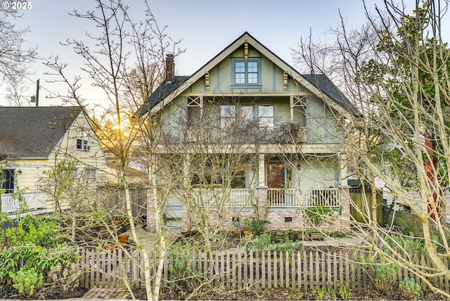 view of front of home featuring a chimney and a porch