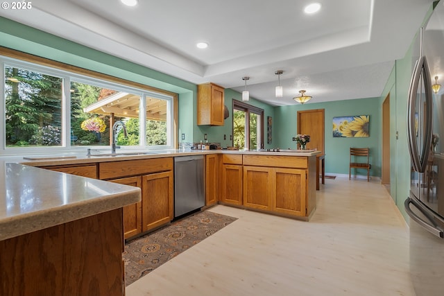 3003 NE 164th St, Ridgefield, WA 98642 - kitchen featuring stainless steel appliances, a sink, a peninsula, light wood finished floors, and brown cabinets
