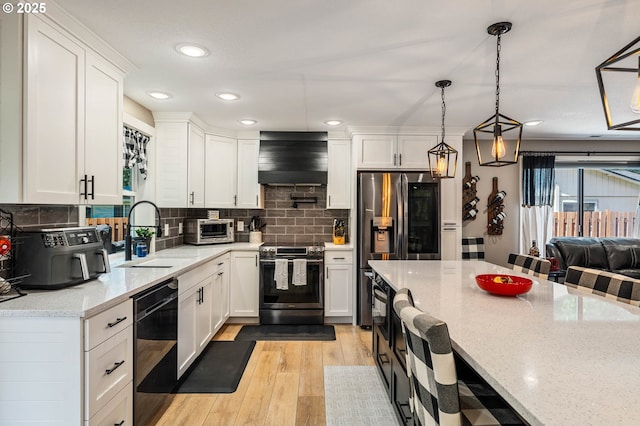 3817 NW Mccann Rd, Vancouver, WA 98685 - kitchen with appliances with stainless steel finishes, premium range hood, white cabinets, backsplash, and recessed lighting