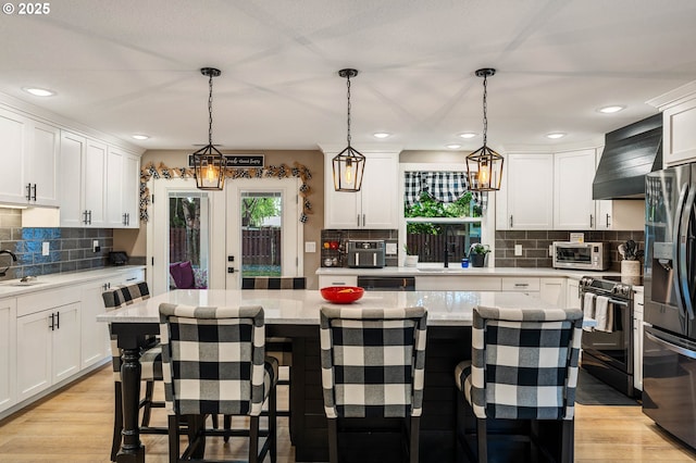 3817 NW Mccann Rd, Vancouver, WA 98685 - kitchen featuring stainless steel appliances, premium range hood, white cabinetry, and recessed lighting