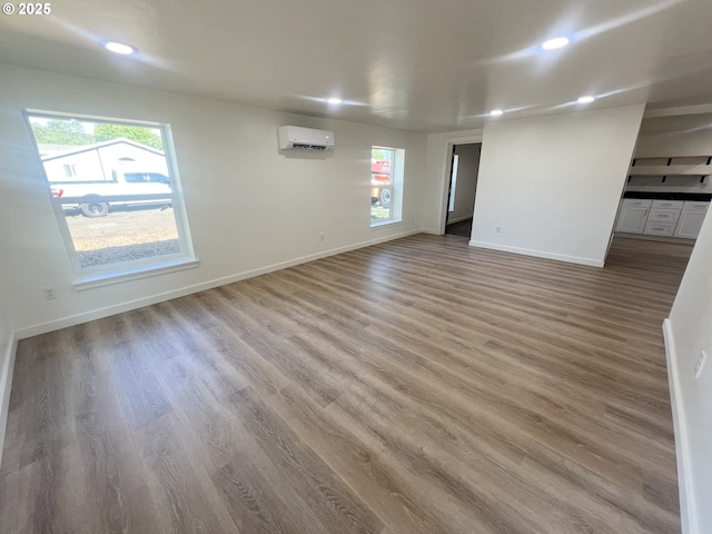 1801 Jackson Ave, La Grande, OR 97850 - unfurnished room with an AC wall unit, light wood-style flooring, baseboards, and recessed lighting