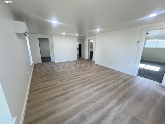 1801 Jackson Ave, La Grande, OR 97850 - unfurnished living room with an AC wall unit, light wood finished floors, recessed lighting, and baseboards