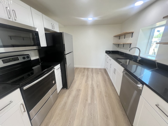 1801 Jackson Ave, La Grande, OR 97850 - kitchen with stainless steel appliances, a sink, open shelves, light wood-style flooring, and dark countertops