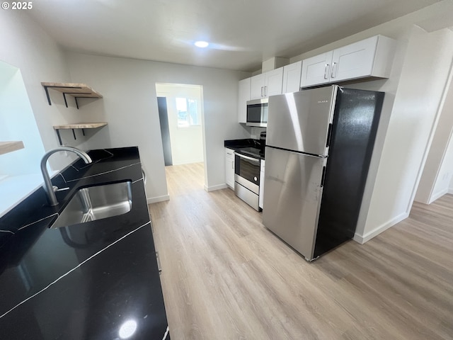 1801 Jackson Ave, La Grande, OR 97850 - kitchen with stainless steel appliances, open shelves, a sink, light wood finished floors, and white cabinets
