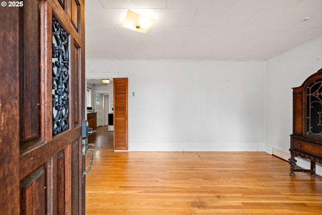 unfurnished living room featuring light wood-type flooring and baseboards