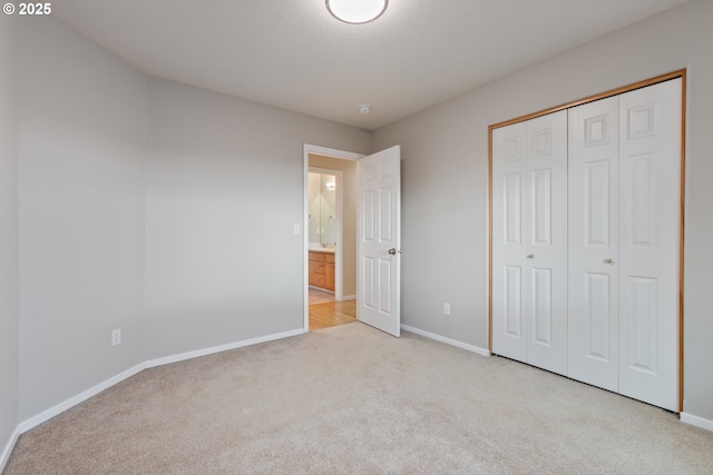 unfurnished bedroom with light colored carpet and a closet