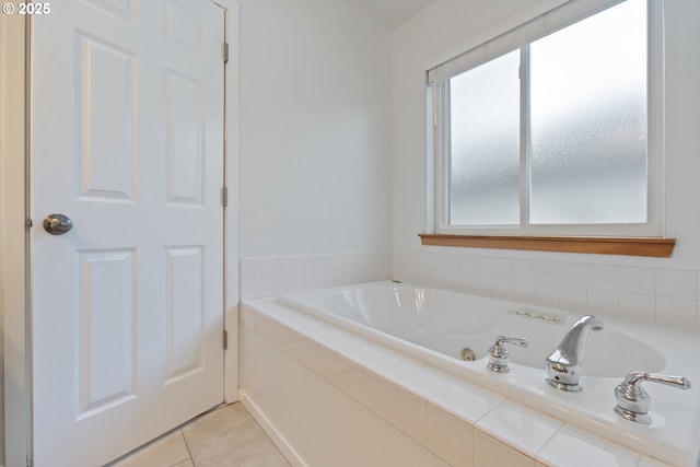 bathroom with tile patterned flooring and tiled tub