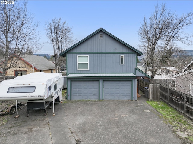 exterior space featuring aphalt driveway, an attached garage, and fence