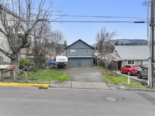 view of front of property featuring fence, a garage, and driveway