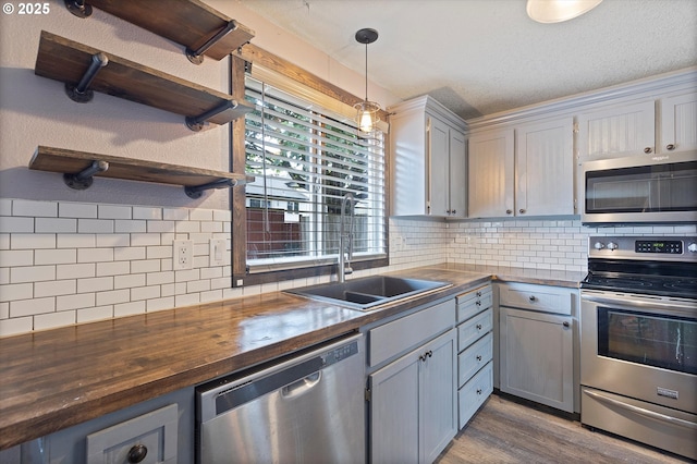 20694 SW Parker Ct, Beaverton, OR 97078 - kitchen with stainless steel appliances, wooden counters, open shelves, dark wood finished floors, and decorative backsplash