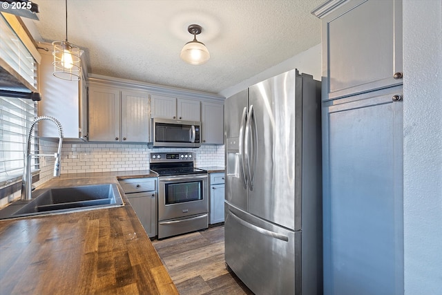 20694 SW Parker Ct, Beaverton, OR 97078 - kitchen with stainless steel appliances, butcher block countertops, tasteful backsplash, a textured ceiling, and dark wood-style flooring